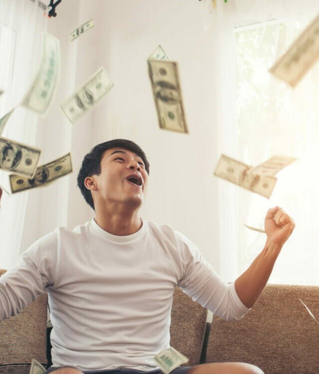 Happy man with cash dollars flying in home office, Rich from bus